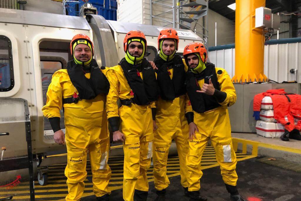 Pilots posing in bright yellow maritime survival suits